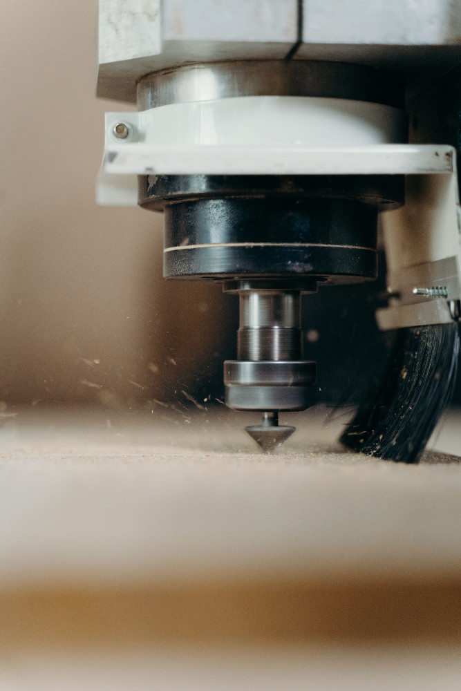 Close-up of a machinist adjusting tooling inside a CNC machine during production